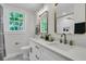 Stylish bathroom with double sinks, gold-trimmed mirrors, and a bright window letting in natural light at 1730 Harrison Ave, Charleston, SC 29407
