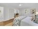Bright bedroom with hardwood floors, white walls, and french doors that lead to the living room at 1730 Harrison Ave, Charleston, SC 29407