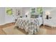 Bright bedroom with hardwood floors, white walls, and a white door that leads outside at 1730 Harrison Ave, Charleston, SC 29407