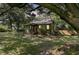 Charming home with mature shade trees and a red front door in a well-maintained yard at 1730 Harrison Ave, Charleston, SC 29407