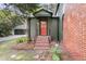 Charming front entry with brick steps, an inviting red door, and lovely landscaping at 1730 Harrison Ave, Charleston, SC 29407