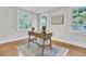Bright office space with hardwood floors, a vintage desk, and three large windows at 1730 Harrison Ave, Charleston, SC 29407
