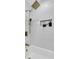 Modern shower showcasing sleek white tile work, bronze hardware, and built-in shelving at 1730 Harrison Ave, Charleston, SC 29407