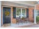 Charming brick condo features a cozy front porch with chairs and a welcoming floral wreath on the front door at 1816 Mepkin Rd # B1, Charleston, SC 29407