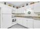 Clean, white kitchen featuring matching appliances and ample storage with upper and lower cabinets to accommodate all of your cooking needs at 1816 Mepkin Rd # B1, Charleston, SC 29407