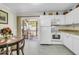 Eat-in kitchen with white cabinets, modern appliances, and a sliding door leading to a charming outdoor patio at 1816 Mepkin Rd # B1, Charleston, SC 29407