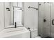 Modern bathroom with sleek white vanity, a glass-enclosed shower, and black hardware at 19 Smith St # B, Charleston, SC 29401