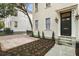 Charming house featuring cream siding, black trim, a brick driveway, manicured garden, and a covered front entrance at 19 Smith St # B, Charleston, SC 29401