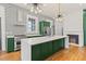 Open kitchen featuring a large island with white countertops, green cabinetry, and modern stainless steel appliances at 19 Smith St # B, Charleston, SC 29401