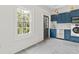 Well-lit laundry room with updated cabinets, tile floors, and stainless-steel appliances at 19 Smith St # B, Charleston, SC 29401