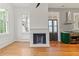 Bright living room with a fireplace and views to the kitchen featuring modern appliances at 19 Smith St # B, Charleston, SC 29401