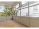 Enclosed porch featuring wood floors and large windows with views of the surrounding yard at 19 Smith St # B, Charleston, SC 29401
