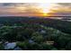 Sunset aerial view of 200 Belted Kingfisher surrounded by beautiful trees and landscape at 200 Belted Kingfisher Rd, Kiawah Island, SC 29455