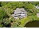 Majestic estate with expansive deck, verdant landscaping, and tranquil pond from above at 200 Belted Kingfisher Rd, Kiawah Island, SC 29455