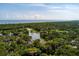 Beautiful aerial view of 200 Belted Kingfisher surrounded by lush greenery, lake, and ocean in the distance at 200 Belted Kingfisher Rd, Kiawah Island, SC 29455