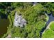 Aerial view of the secluded home nestled among beautiful trees, a lush lawn, and a serene lake at 200 Belted Kingfisher Rd, Kiawah Island, SC 29455