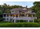 Lovely two-story home featuring an arched window, a spacious deck, and lush green landscaping at 200 Belted Kingfisher Rd, Kiawah Island, SC 29455