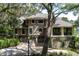Elegant home featuring a three-car garage, basketball hoop, and lush greenery surrounding the property at 200 Belted Kingfisher Rd, Kiawah Island, SC 29455