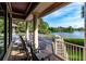 Covered porch with lake views, featuring classic columns, elegant seating, and providing a relaxing outdoor space at 200 Belted Kingfisher Rd, Kiawah Island, SC 29455