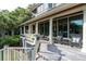 Expansive porch with rocking chairs and panoramic views of the surrounding trees at 200 Belted Kingfisher Rd, Kiawah Island, SC 29455