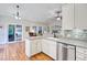 An open-concept kitchen featuring wooden floors, pendant lighting, stainless steel appliances, and seamless access to living areas at 2008 Welsh Pony Dr, Mount Pleasant, SC 29429