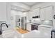 Modern kitchen with stainless steel appliances, white cabinetry, and a view of the laundry room at 2008 Welsh Pony Dr, Mount Pleasant, SC 29429
