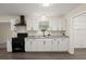 Updated kitchen features granite countertops, white cabinets, and a sleek black range hood at 205 Owens Dr, Summerville, SC 29485