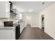 Modern kitchen featuring white cabinets, black appliances, granite countertops, and hardwood floors at 205 Owens Dr, Summerville, SC 29485