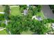 An aerial view shows a home nestled among lush trees on a large lot with a pond and separate garage at 206 Chaussee Blvd, Summerville, SC 29483
