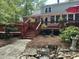 View of the multilevel back deck with red stairs, an umbrella, potted plants, and beautiful landscaping at 206 Chaussee Blvd, Summerville, SC 29483