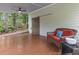 Covered back porch with a brown wicker couch with red cushions and a door to the backyard at 206 Chaussee Blvd, Summerville, SC 29483