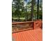 Wooden deck offering scenic views of a lush backyard, stone patio, and lake at 206 Chaussee Blvd, Summerville, SC 29483