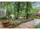 Beautiful backyard with a stone path, mature trees, landscaping, and a glimpse of the home's exterior at 206 Chaussee Blvd, Summerville, SC 29483