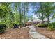 Spacious backyard featuring lush landscaping, a stone pathway, fire pit, and a charming outdoor seating area at 206 Chaussee Blvd, Summerville, SC 29483