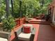 Cozy wooden deck with comfortable seating, lounge chairs, potted plants, and lush trees at 206 Chaussee Blvd, Summerville, SC 29483