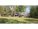 Exterior view of a charming house, displaying its well-manicured lawn and surrounded by a beautiful array of trees and shrubs at 206 Chaussee Blvd, Summerville, SC 29483