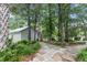 Charming exterior view of the home with a stone pathway winding through lush landscaping and mature trees at 206 Chaussee Blvd, Summerville, SC 29483