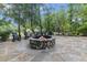 Backyard stone fire pit with adirondack chairs surrounded by lush trees at 206 Chaussee Blvd, Summerville, SC 29483