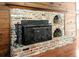 Close-up of brick fireplace featuring wood stove and wood accent wall at 206 Chaussee Blvd, Summerville, SC 29483