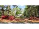 Charming two-story home with a lush front yard, blooming azaleas, and a black iron fence adding to its curb appeal at 206 Chaussee Blvd, Summerville, SC 29483