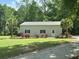 Detached garage with silver roof and light-green paint, accented by palm trees and beautiful roses at 206 Chaussee Blvd, Summerville, SC 29483