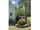 View of the manicured yard with mature landscaping, including a palm tree, rose bushes and lush greenery at 206 Chaussee Blvd, Summerville, SC 29483