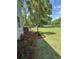 Side yard view of lush landscaping, red roses, a palm tree, and a view of the serene lake at 206 Chaussee Blvd, Summerville, SC 29483