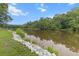 Beautiful tranquil view of lake waters with rocky shoreline and lush trees in the background at 206 Chaussee Blvd, Summerville, SC 29483
