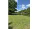 Scenic lakefront view with lush green lawn, mature trees and clear blue sky at 206 Chaussee Blvd, Summerville, SC 29483