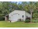 A spacious garage outbuilding featuring a roll-up door, side entry, and well-maintained landscaping at 206 Chaussee Blvd, Summerville, SC 29483