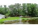The fountain in the pond, garage and home are framed by trees and greenery at 206 Chaussee Blvd, Summerville, SC 29483