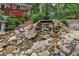 A serene rocky waterfall feature surrounded by lush greenery and landscaping, adding tranquility to the outdoor space at 206 Chaussee Blvd, Summerville, SC 29483