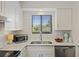 Bright kitchen featuring white cabinets, stainless steel appliances, and a view from the window at 2063 Long Bend Dr, Seabrook Island, SC 29455
