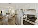 Open concept kitchen with stainless steel appliances flows into dining area with backyard view at 2063 Long Bend Dr, Seabrook Island, SC 29455